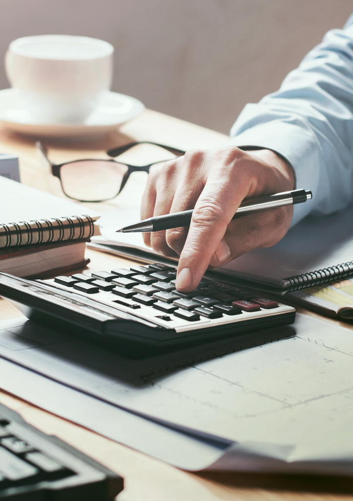 Accountant using calculator on cluttered desk