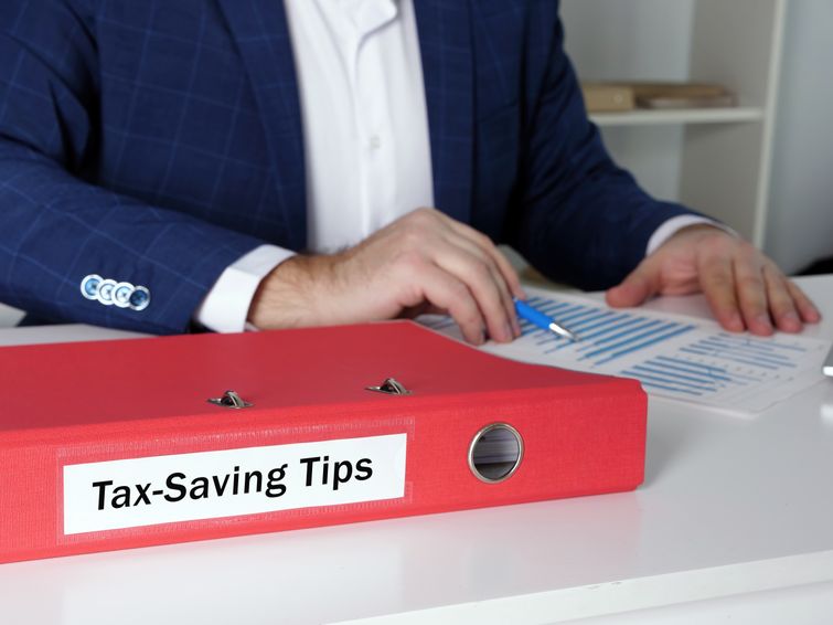 Dental accountant with a binder of tax-saving tips on desk