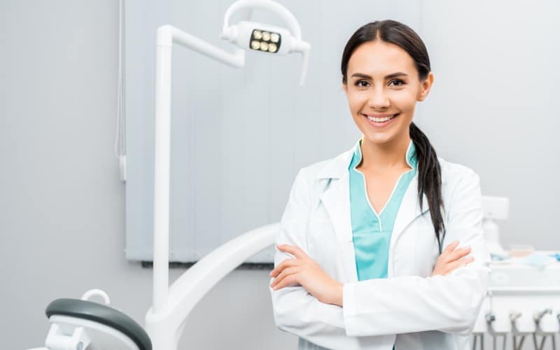 beautiful dentist standing crossed arms dental clinic