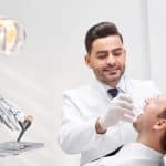 Professional dentist standing confidently in modern dental clinic