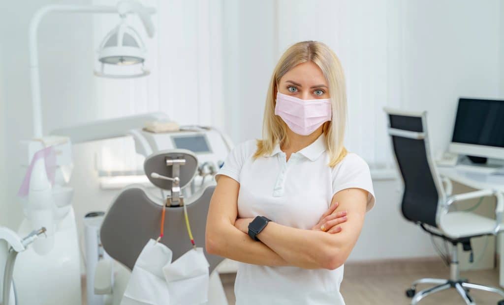 Confident dental professional with crossed arms ready for patients