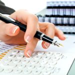 Professional business accounting documents and financial calculations on desk