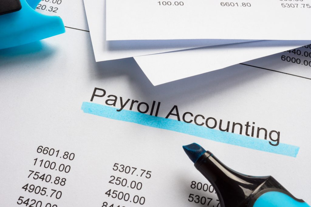 Payroll accounting documents with blue marker for calculations