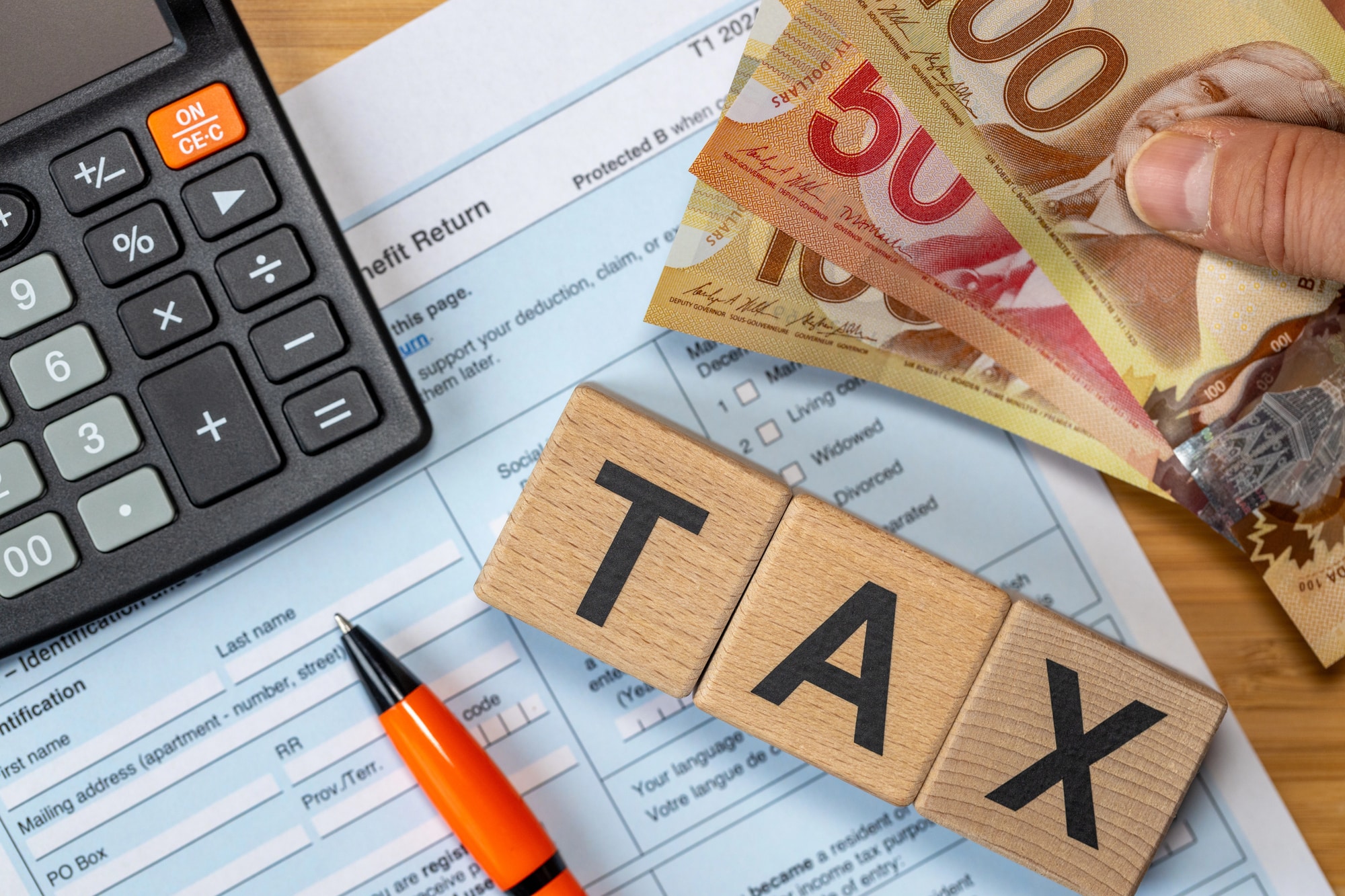Canadian tax forms with calculator and dollar bills preparation
